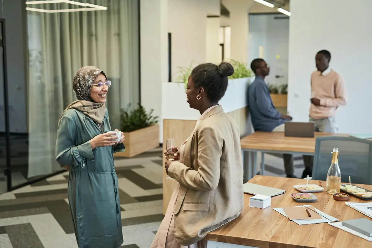 Duas profissionais em conversa de mentoria em ambiente corporativo